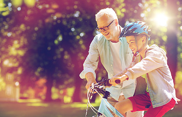 Image showing grandfather and boy with bicycle at summer park