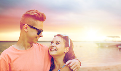 Image showing happy teenage couple hugging on summer beach