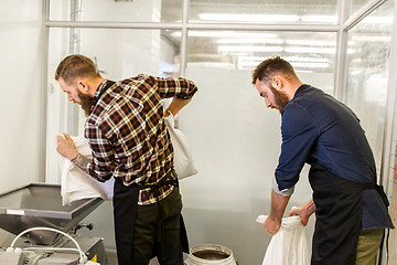Image showing men with malt bags and mill at craft beer brewery