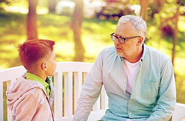 Image showing grandfather and grandson talking at summer park