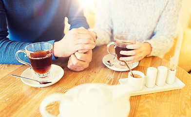 Image showing close up of couple drinking tea at cafe