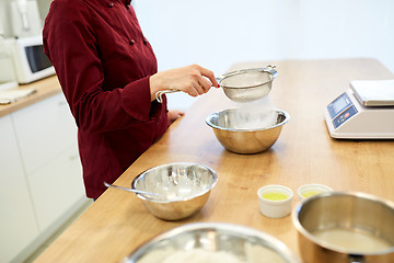 Image showing chef sifting flour in bowl making batter or dough