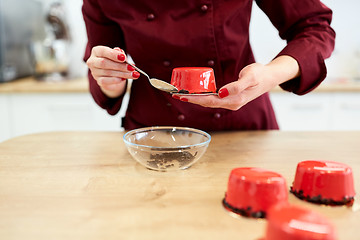 Image showing chef decorating mirror glaze cakes at pastry shop