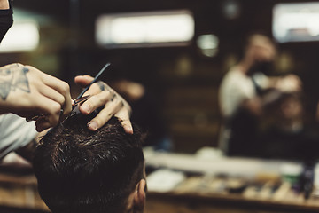 Image showing Crop barber doing haircut for client