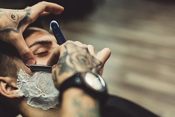 Image showing Barber shaving client