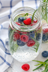 Image showing Ice sparkling water, berries and tarragon in jar.