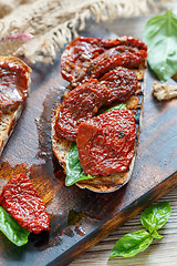 Image showing Bruschetta with sun-dried tomatoes and basil leaves.