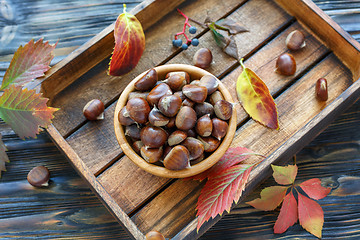 Image showing Bowl with ripe chestnuts on a wooden box.