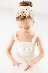 Image showing Little ballerina girl in a tutu. Adorable child dancing classical ballet in a white studio.