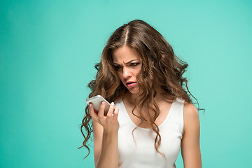 Image showing The portrait of disgusted woman with mobile phone