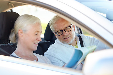 Image showing happy senior couple with map driving in car