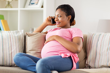 Image showing happy pregnant woman calling on smartphone at home