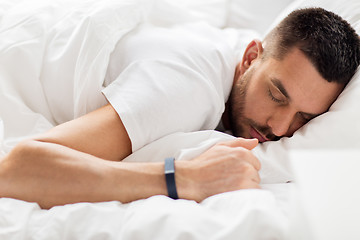 Image showing man with smartwatch sleeping in bed