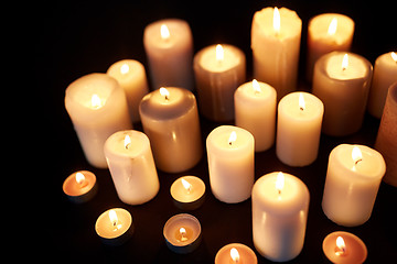 Image showing candles burning in darkness over black background