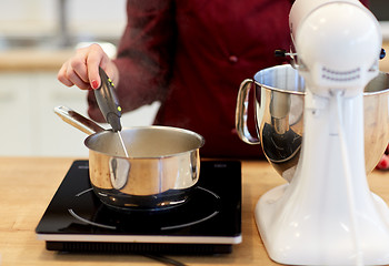 Image showing chef measuring temperature in pot at kitchen