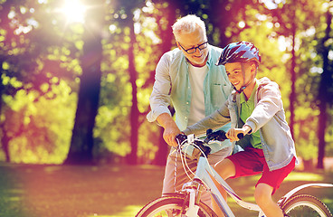 Image showing grandfather and boy with bicycle at summer park