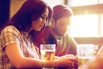 Image showing friends with smartphones drinking beer and at pub