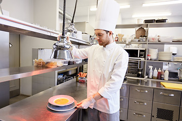 Image showing happy male chef cooking food at restaurant kitchen