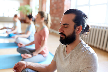 Image showing man with group of people meditating at yoga studio