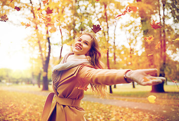 Image showing happy woman having fun with leaves in autumn park