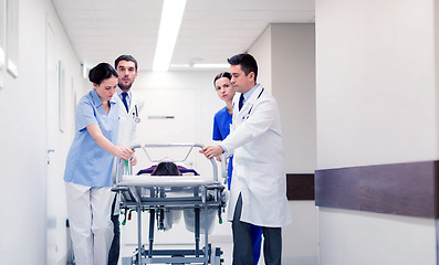 Image showing medics with woman on hospital gurney at emergency