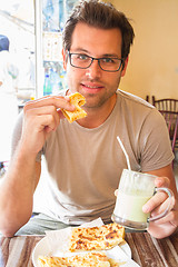 Image showing Man eating traditional moroccan breakfast in coffee shop.