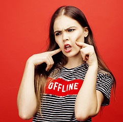 Image showing young pretty emitonal posing teenage girl on bright red background, happy smiling lifestyle people concept 