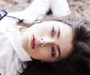 Image showing young pretty brunette woman in her bedroom sitting at window, happy smiling lifestyle people concept