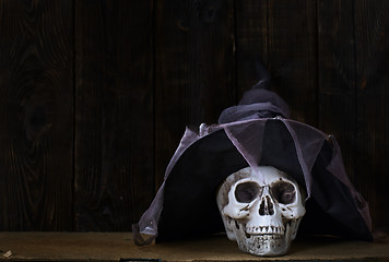 Image showing Human skull with magician hat at the wooden wall