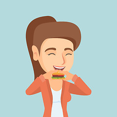 Image showing Young caucasian joyful woman eating hamburger.