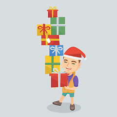 Image showing Caucasian boy holding christmas gift boxes.