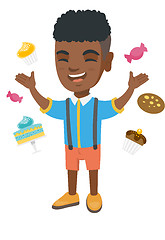 Image showing Happy african boy standing among lots of sweets.