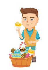 Image showing Boy holding a cupcake and stroking his belly.