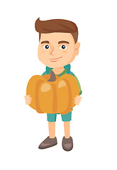 Image showing Caucasian boy standing with a big orange pumpkin.