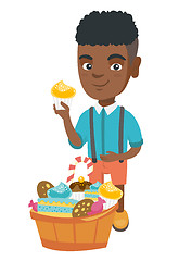 Image showing Boy holding a cupcake and stroking his belly.