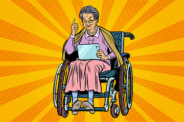 Image showing elderly woman disabled person in a wheelchair, gadget tablet