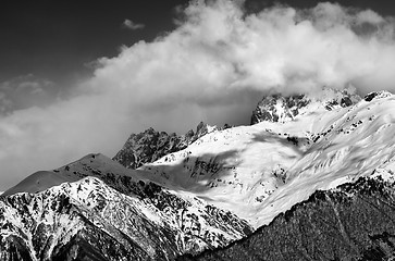 Image showing Black and white view on snow mountains in clouds in winter sun d