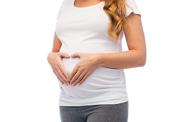 Image showing pregnant woman making heart gesture on her belly