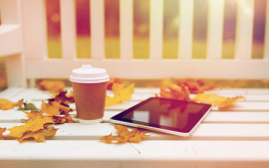 Image showing tablet pc and coffee cup on bench in autumn park