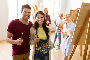 Image showing artists with brushes painting at art school