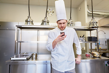 Image showing chef cook with smartphone at restaurant kitchen