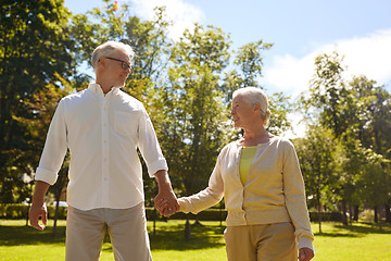 Image showing happy senior couple walking at summer city park