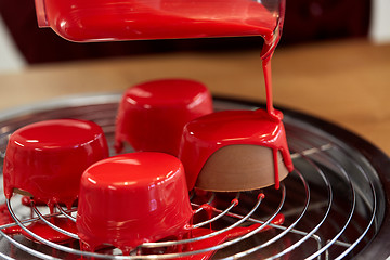 Image showing jug pouring glaze to cakes at pastry shop