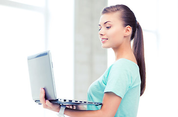 Image showing smiling student girl with laptop at school