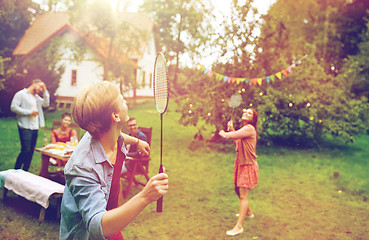 Image showing happy friends playing badminton at summer garden