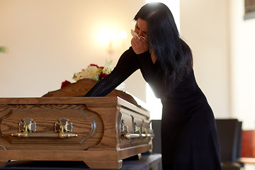 Image showing woman with coffin crying at funeral in church