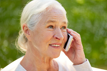 Image showing happy senior woman calling on smartphone in summer