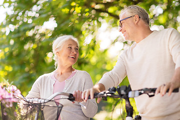 Image showing happy senior couple with bicycles at summer park