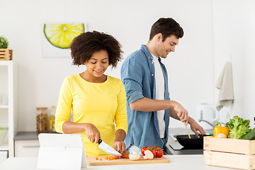 Image showing happy couple cooking food at home kitchen