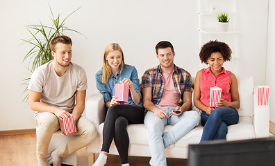 Image showing happy friends with popcorn watching tv at home